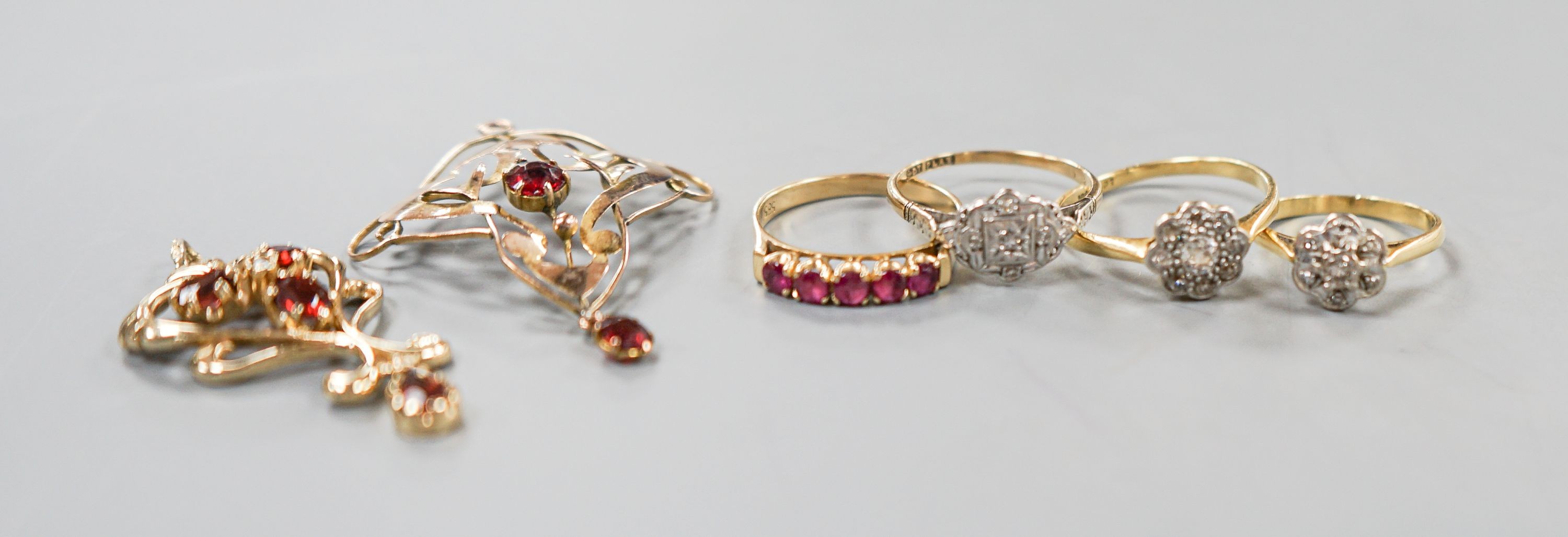 Two 18ct and diamond cluster rings, gross 5.3 grams, a 585 and diamond chip ring, gross 1.7 grams, a 9ct gold gem set ring and two 9ct pendants, gross 8.9 grams.